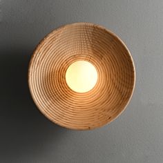 a light that is on the side of a wall next to a gray wall,