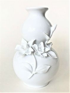 a white vase sitting on top of a table