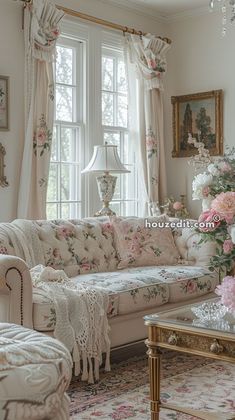 a living room filled with lots of furniture and flowers on the table in front of a window