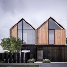 two wooden buildings with windows on the top and bottom floors are shown in front of a black fence