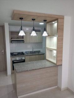 an empty kitchen with wooden cabinets and marble counter tops in the middle of the room