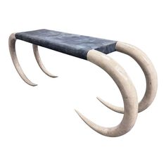 a bench made out of two horns with long curved tails on the top and bottom