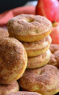 a pile of doughnuts sitting next to an apple