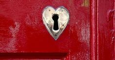 a red door with a heart shaped keyhole