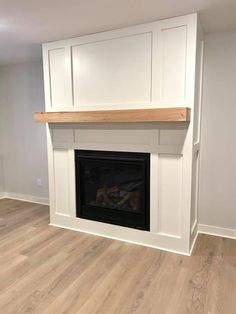 an empty room with a fireplace and white cabinets