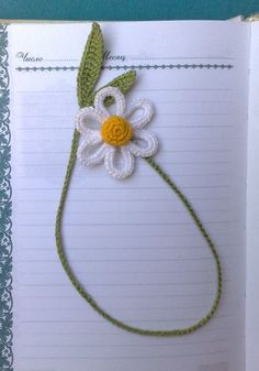 an open book with crocheted flowers and leaves on it's cover, in the shape of a flower