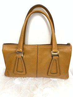 This Tod's bag Features light brown tan textured leather  Main top zippered compartment with 2 wall slip pockets and 2 main pockets  Measures app 12.5"x7.5"x4"  the strap is 8" drop. Condition very good pre owned condition. Comes from a smoke free home. Tod's Bag, Brown Leather Texture, Tods Bag, Light Brown Leather, Hobo Bags, Leather Texture, Feature Light, Hobo Handbags, May 17