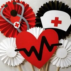 some paper flowers are arranged in the shape of heart and nurse hats with a stethoscope on top