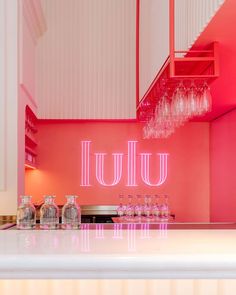 a kitchen with pink walls and white counter tops, chandelier hanging from the ceiling