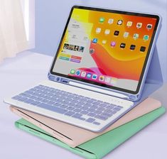 an open laptop computer sitting on top of a stack of books