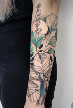 a woman's arm with flowers and leaves tattooed on her left arm, in black and white