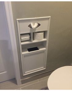 a toilet paper dispenser in the corner of a bathroom with a roll of toilet paper on it