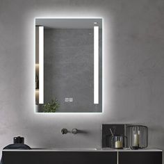 a bathroom with a sink, mirror and lights on the wall above it's counter