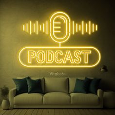 a couch sitting in front of a neon sign with the word podcast written on it