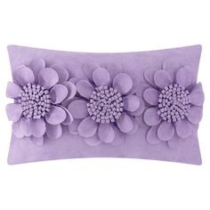 a purple pillow with three large flowers on the front and one small flower on the back