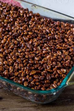 a glass dish filled with nuts on top of a wooden table