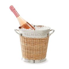 a bottle of wine sitting in a basket filled with ice and water on a white background