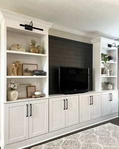 a living room with built in cabinets and a flat screen tv