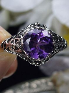 Natural Amethyst Ring Daisy Design#66 In Stock Size 6 Inspired by the Art Nouveau movement of the early 20th century, I now offer this lovely reproduction filigree ring in sterling silver. This gorgeous ring is set with a genuine/natural 1.5ct purple amethyst gemstone; which has a great shine and very good clarity. The round full cut purple amethyst gemstone is 8mm (5/16th of an inch) in diameter. The ring measures 12mm NS on the finger. The inside of the band is marked 925 for sterling. Notice Purple Intricate Design Promise Ring, Heirloom Purple Amethyst Ring With Intricate Design, Purple Promise Ring With Intricate Design, Purple Amethyst Ring With Intricate Design For Promise, Purple Anniversary Rings With Intricate Design, Purple Oval Filigree Ring For Anniversary, Purple Amethyst Promise Ring With Intricate Design, Purple Amethyst Ring With Intricate Design, Amethyst Ring With Intricate Design