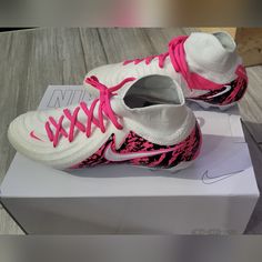 a pair of white and pink nike shoes on top of a box with laces