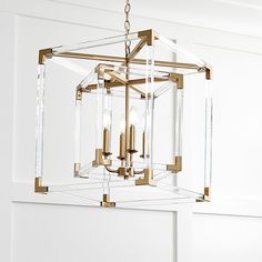 a chandelier hanging from the ceiling with clear glass cubes and gold accents