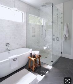 a white bath tub sitting next to a walk in shower