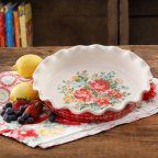 a bowl with fruit on it sitting next to some lemons and strawberries in front of them