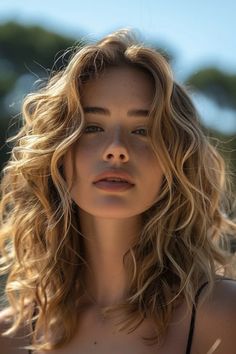 Close-up of a young woman with sunlit wavy hair and a contemplative expression against a blurred natural background. Hairstyle Ideas For School, Hair Cut For Girls, Dark Balayage