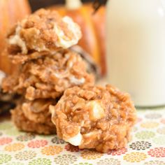 three oatmeal cookies stacked on top of each other next to a glass of milk