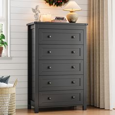 a chest of drawers in a room with a wreath on the wall and candles lit