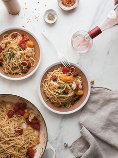 two bowls of pasta with shrimp and tomatoes