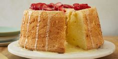 a cake that has been cut in half and is on a white plate with strawberries