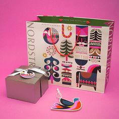 a gift box with an ornament on it next to a card and sticker