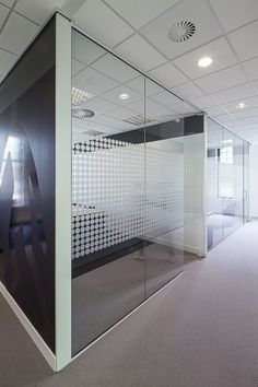 an empty office with glass partitions on the wall