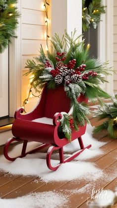 a red sleigh decorated with pine cones and evergreens