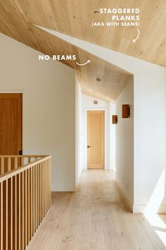 an empty hallway with wood floors and white walls, has no beams on the ceiling