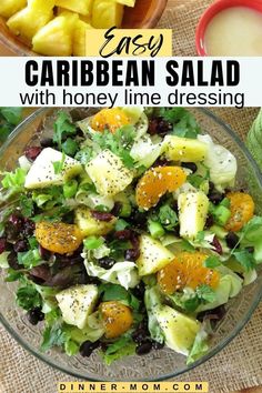 a salad with oranges, lettuce and other fruits in it on a table