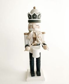 a wooden nutcracker with a crown on it's head sitting on a white surface