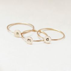 One gold letter ring. Personalize a gift she'll treasure with our gold initial ring. An adorably petite initial, imprinted on a 14k gold filled disk - paired with a super skinny (1mm) gold filled band - creates the perfect stacking ring, customized with your monogram. Lovely as a stand alone. Also sits beautifully with multiple initials stacked or our hammered gold stacking ring bands. This gold initial ring arrives custom made to order in your size hand stamped with the letter of your choice. A Personalized Yellow Gold Initial Ring For Everyday, Everyday Personalized Yellow Gold Initial Ring, Gold Stackable Rings With Initials For Everyday, Everyday Gold Stackable Rings With Initials, Dainty 14k Gold Stackable Initial Ring, Everyday Stackable Yellow Gold Rings With Initials, Simple Stackable Initial Ring, Minimalist 14k Gold Monogram Rings, Minimalist Monogram 14k Gold Rings