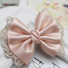 a pink bow with sequins on it sitting on top of a white table