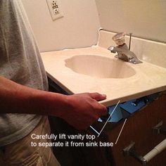 a man standing in front of a bathroom sink with the words carefully lift vanity top to separate it from sink base