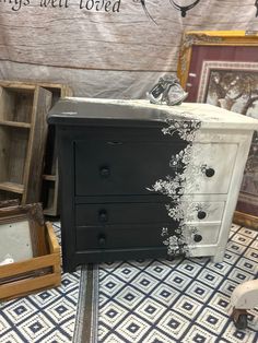 an old dresser is painted black and white with silver flakes on the drawer tops