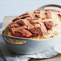 a casserole dish with meat and cheese in it on a wooden table top