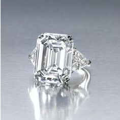 an emerald - cut diamond ring with three diamonds on the band and two side stones