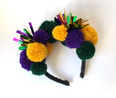 a close up of a headband made out of crochet and pom - poms