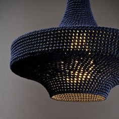 a blue lamp hanging from the ceiling with holes in it's fabric coverings