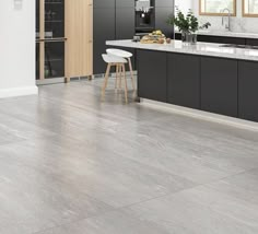 a large kitchen with black cabinets and white counter tops is pictured in this image, there are two stools on the island