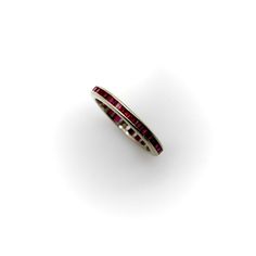 This is part of Chairish’s Fine Jewelry assortment.  This 14k white gold ring contains square Table Cut rubies channel set into an eternity band. The rubies have a rich red color and the lines of the square stones catch the light in a beautiful sparkle.   The band contain 34 synthetic rubies. It is 2.3 mm wide and weighs 1.46 grams.   Looks great stacked with the Sapphire Art Deco Platinum Eternity Band, or can be worn alone for a sleek and simple line of color.   Ring size 6. Elegant Red Ruby Eternity Band, Luxury Ruby Jewelry Channel Set, Red Ruby Eternity Band In Fine Jewelry Style, Luxury Ruby Ring Channel Set For Anniversary, Luxury Ruby Channel Set Jewelry, Classic Ruby Eternity Band For Formal Occasions, Elegant Red Stackable Eternity Band, Elegant Red Gemstone Eternity Band, Luxury Channel Set Ruby Jewelry