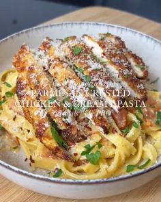 a white bowl filled with pasta covered in sauce and parmesan cheese on top