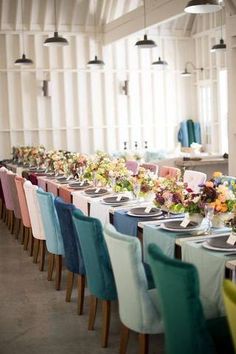 a long table set with colorful chairs and place settings